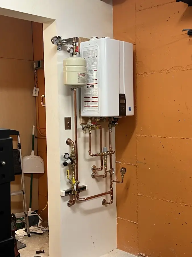 Plumbing technician inspecting water heater connections in Newman